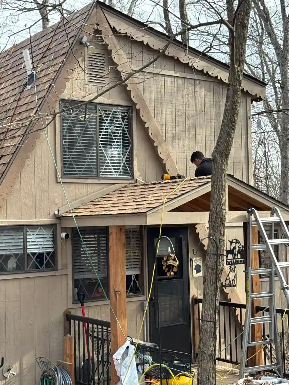 Contractor installing new soffit trim along the roofline of a two-story Missouri home